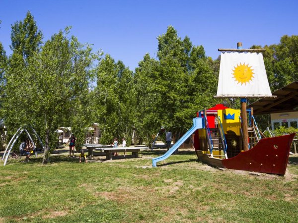 Un parco giochi con una nave colorata e un'area picnic.