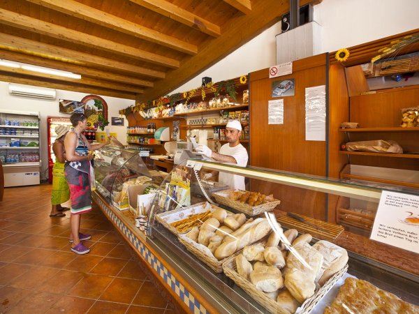Un panificio con pane e prodotti freschi al bancone.