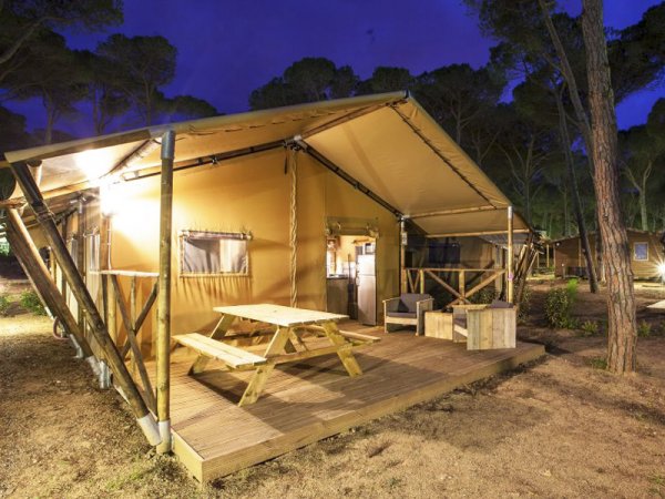 Una tenda da campeggio con area picnic, di sera.