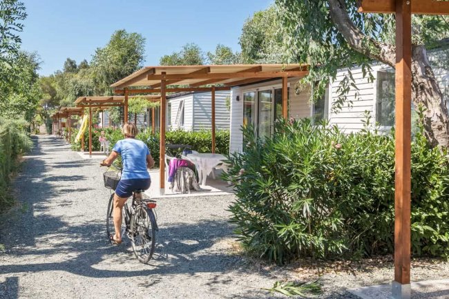 Persona in bicicletta vicino a bungalow con terrazze.