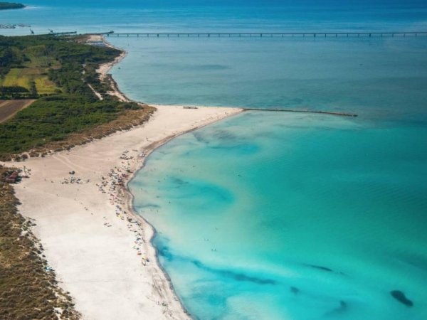 Spiaggia con sabbia bianca e mare turchese.