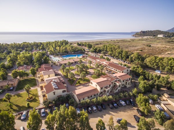 Vista aerea di un resort con piscina vicino al mare.