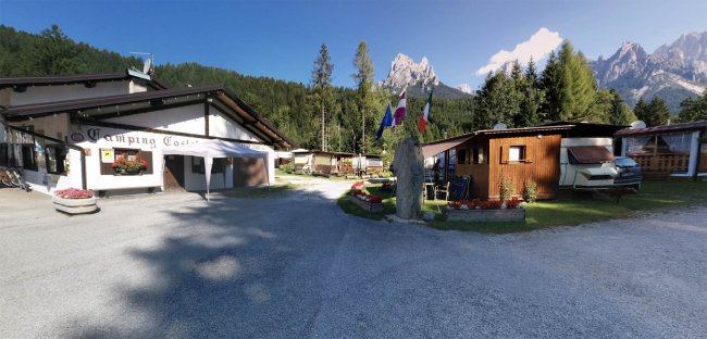 Ingresso di un campeggio con bandiere e fiori.