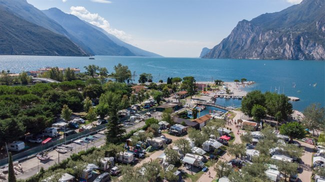 Vista dall'alto di un campeggio fronte lago e montagne.