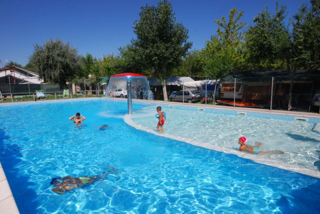 Piscina all'aperto con bambini che si divertono.