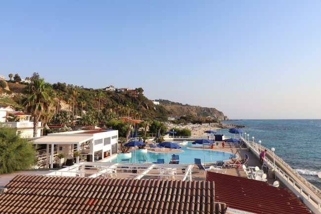 Piscina e mare con fondo collinare.
