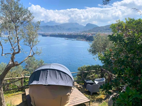 Tenda su terrazza con vista mare e montagna.