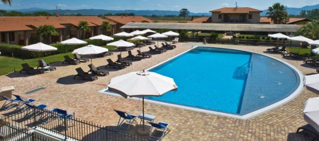 Piscina all'aperto con sdraio e ombrelloni.