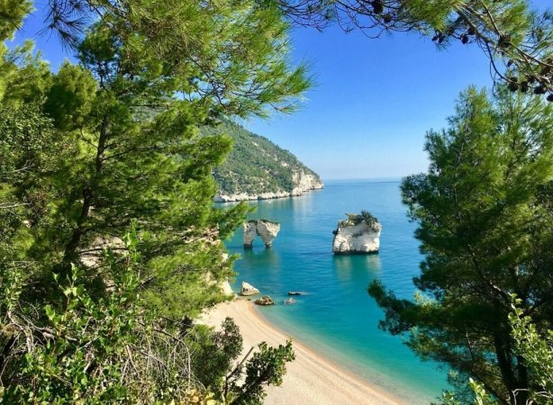 Una spiaggia con mare turchese e scogli.