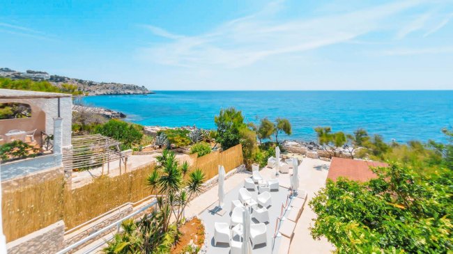 Vista mare con terrazza e vegetazione.