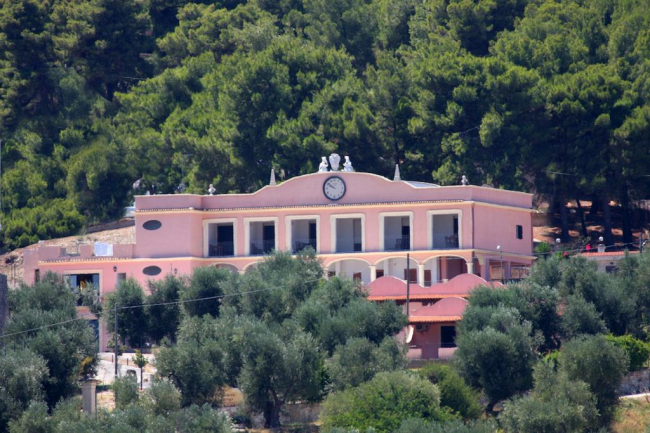 Edificio rosa circondato da alberi.