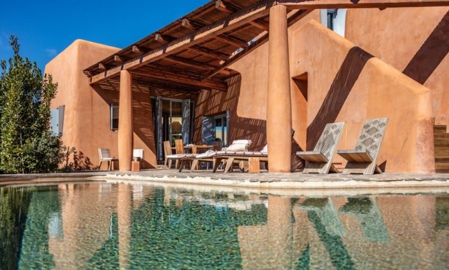 Patio con piscina e sedie a sdraio.