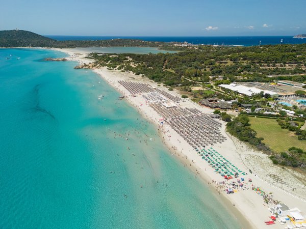 Spiaggia affollata con mare turchese.