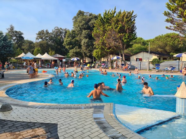 Piscina all'aperto con molte persone.