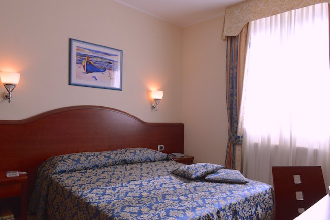 Una camera da letto con letto matrimoniale e finestra.