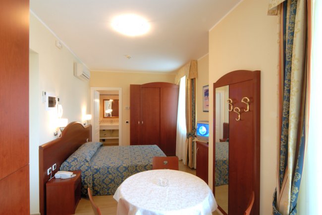 Camera con letto, armadio e tavolo rotondo.