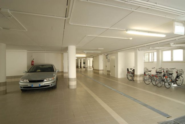 Garage con auto e biciclette parcheggiate.