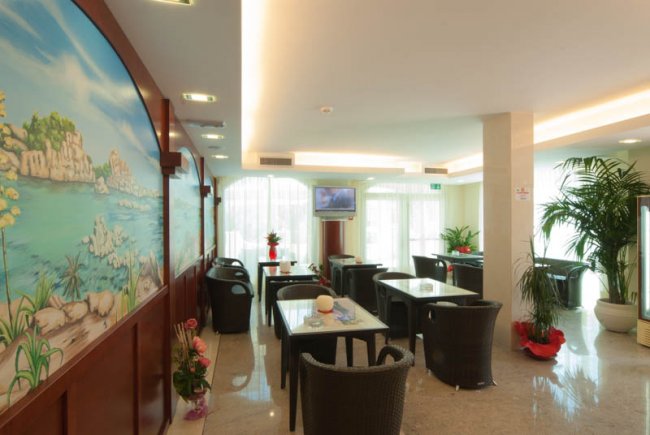 Sala lounge con tavoli e sedie di vimini.