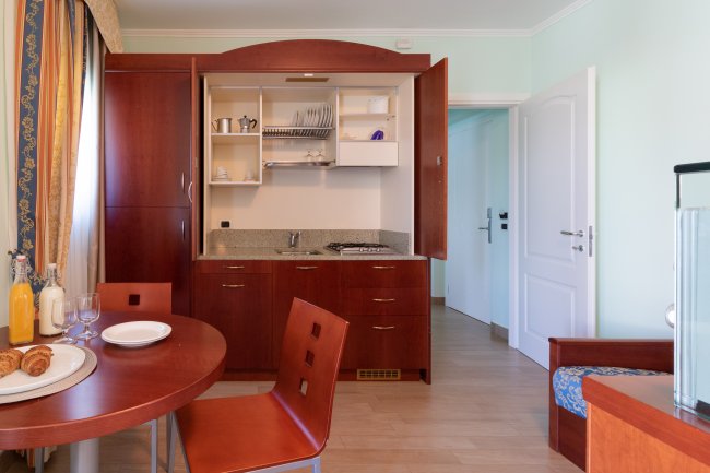 Cucina moderna con tavolo rotondo e sedie rosse.