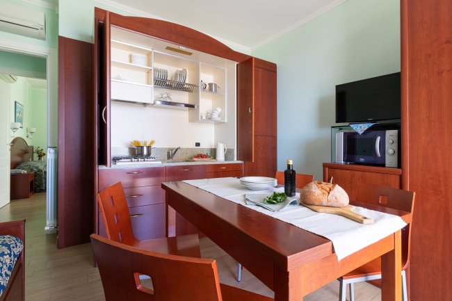 Cucina moderna con tavolo in legno e pane su tagliere.