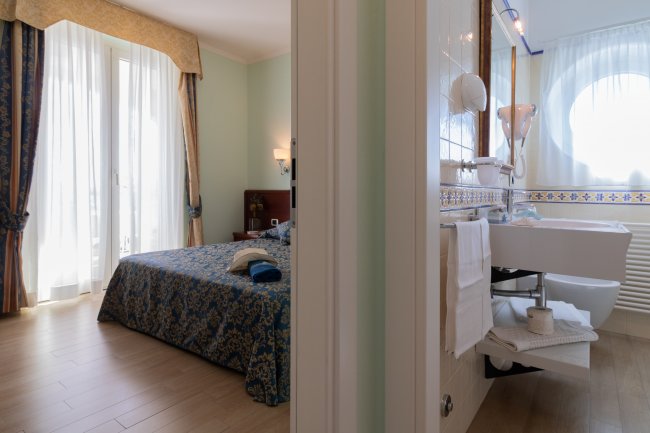 Camera da letto e bagno separati da parete.