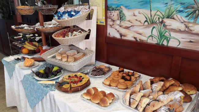 Buffet colazione con dolci e frutta.