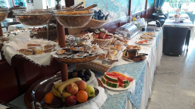Buffet colazione con frutta e cereali.