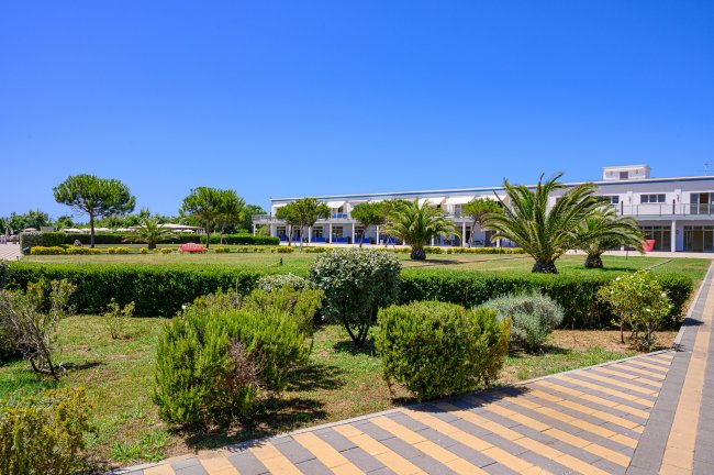 Edificio moderno con giardino e palme.