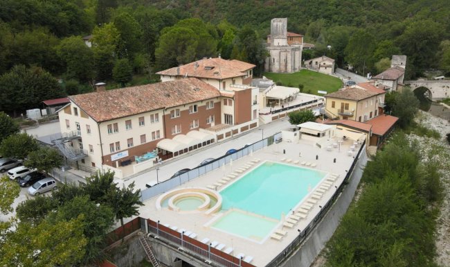 Un complesso con piscina in un'area verde.