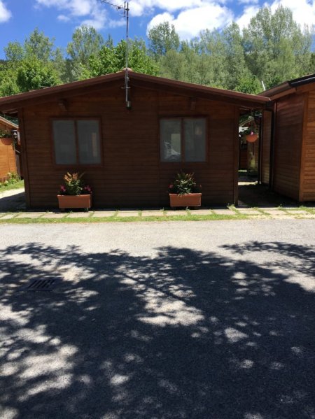 Casetta in legno con due finestre e fioriere.