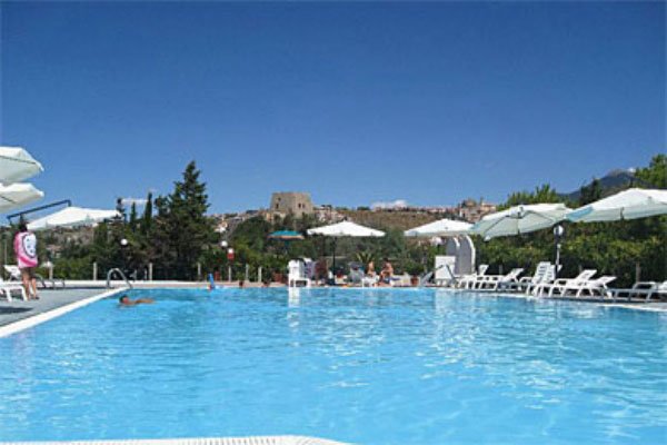 Piscina all'aperto con lettini e ombrelloni.