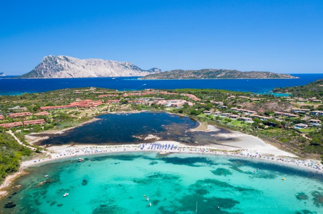 Costa con spiaggia e acque cristalline.