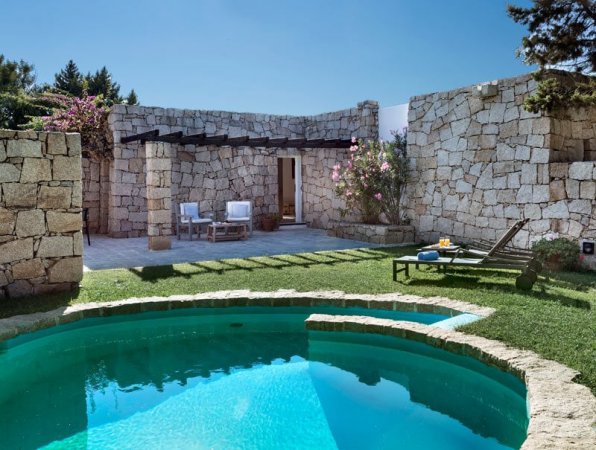 Cortile con piscina circolare e mura di pietra.