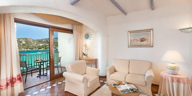 Soggiorno con divani e vista mare dal balcone.