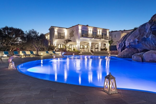 Villa con piscina illuminata di notte.