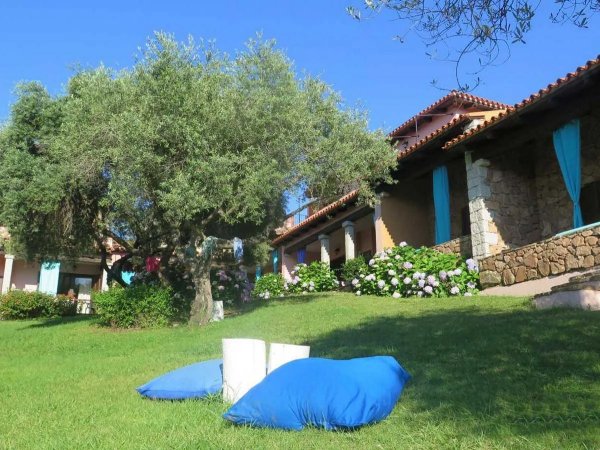 Veranda di case in pietra con cuscini blu su prato verde.