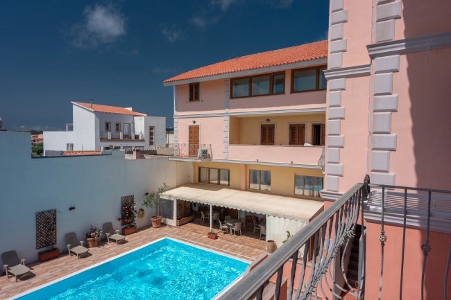 Vista su piscina e edificio a più piani con balconi.