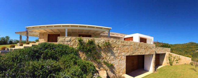 Casa in pietra con veranda e prato.