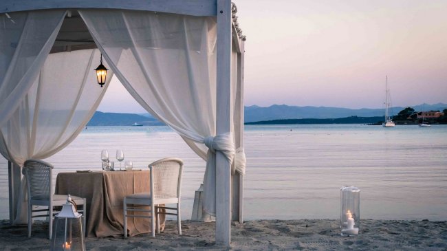 Tavolo all'ombra sulla spiaggia al tramonto.