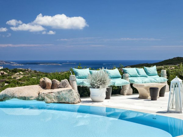 Piscina con vista su mare e colline.
