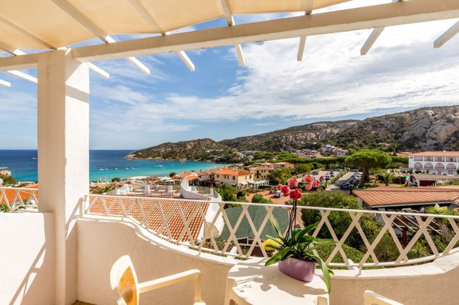 Balcone con vista mare, tavolo e sedia.