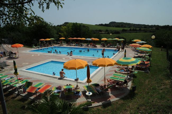Due piscine circondate da ombrelloni colorati.