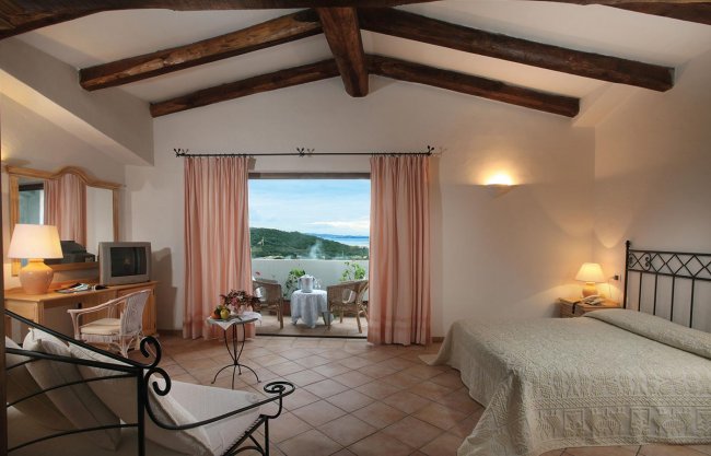 Una camera con letto matrimoniale e vista sul mare.