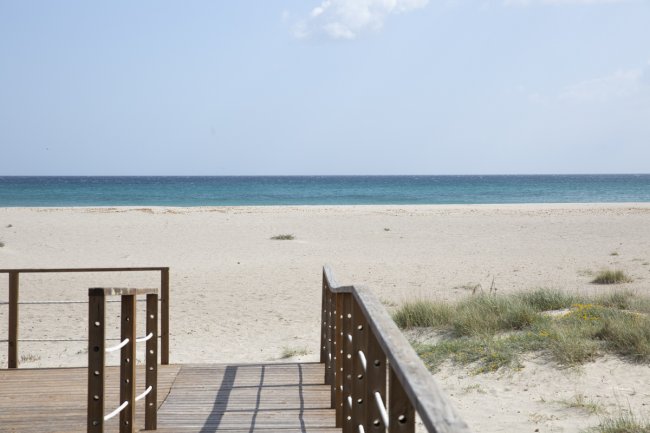 Passerella in legno verso la spiaggia e il mare.