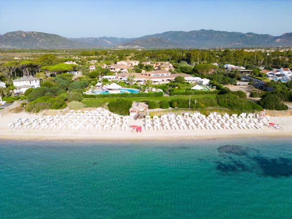 Vista aerea di un resort con spiaggia e ombrelloni.