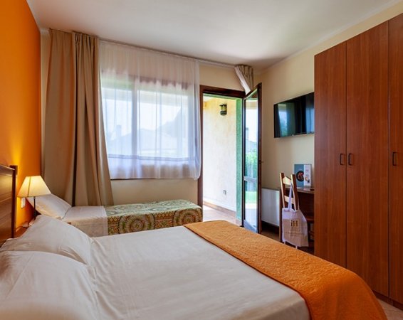 Camera con letto matrimoniale, letto singolo e porta che dà all'esterno.