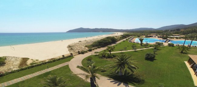 Vista aerea di una spiaggia con una piscina e prato verde.