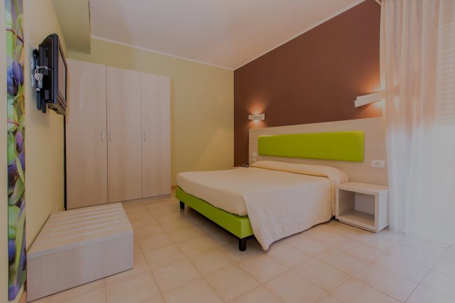 Camera con letto matrimoniale e arredi verde chiaro.