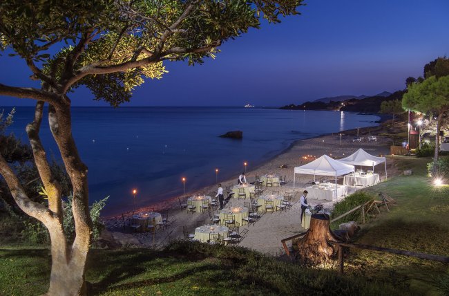 Cena elegante in spiaggia sotto un cielo stellato.