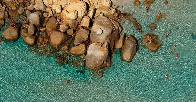 Acqua cristallina con rocce e bagnanti.